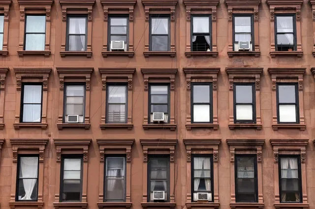 FILE PHOTO: Air conditioning units fill the windows of an apartment building in the Harlem neighborhood in New York City, U.S., August 6, 2025. REUTERS/Kylie Cooper/File Photo