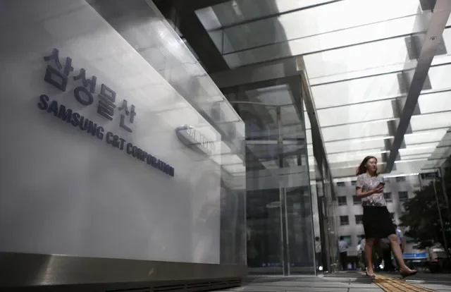 صورة أرشيفية: موظف يمر بجوار شعار Samsung C&T Corp في المقر الرئيسي للشركة في سيول، كوريا الجنوبية، 16 يوليو 2015. رويترز/كيم هونغ-جي/صورة أرشيفية