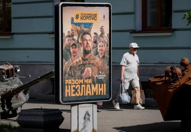 FILE PHOTO: A man walks past a poster depicting military commander Andriy Biletsky, advertising the Third Army Corps of the Ukrainian Armed Forces, to improve the mobilisation process amid Russia's attack on Ukraine, in Kyiv, Ukraine, August 23, 2026. REUTERS/Gleb Garanich/ File Photo