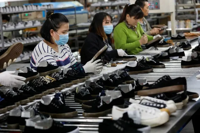 FILE PHOTO: Employees work at a shoe factory for export in Hanoi, Vietnam December 29, 2020. REUTERS/Kham/ File Photo