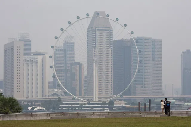 FILE PHOTO: The Singapore Flyer and commercial buildings are shrouded in haze at the Marina Bay area in Singapore, September 15, 2026. REUTERS/Ore Huiying/File Photo