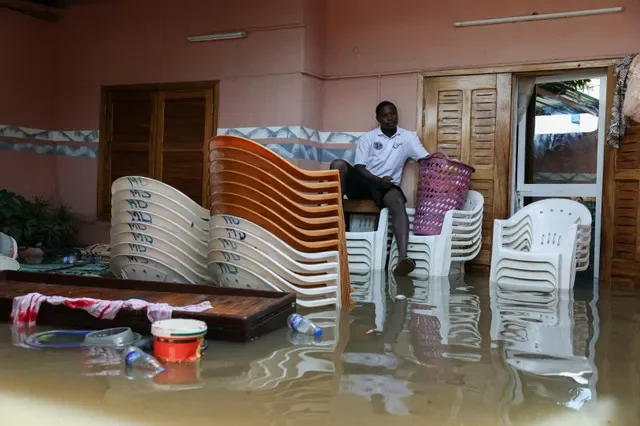 Un hombre se sienta sobre el agua acumulada mientras muebles y pertenencias se amontonan dentro de una casa inundada tras las intensas lluvias en Dakar, Senegal, el 5 de octubre de 2026. REUTERS/Misper Apawu