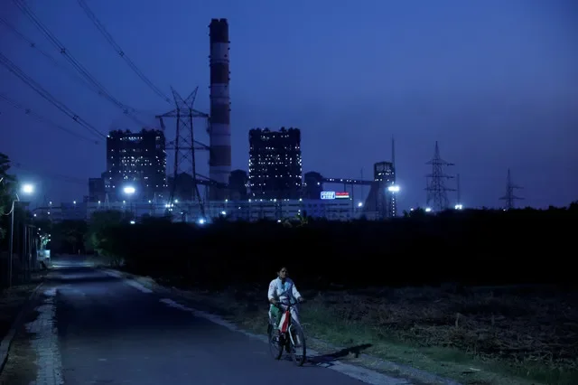 ภาพแฟ้ม: หญิงคนหนึ่งปั่นจักรยานผ่านโรงไฟฟ้า NTPC ในเมืองโซลาปูร์ ประเทศอินเดีย เมื่อวันที่ 3 มีนาคม 2025 REUTERS/ฟรานซิส มาสคาเรนฮาส/ภาพแฟ้ม