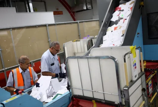 พนักงาน Royal Mail กำลังคัดแยกจดหมายที่โรงงานแปรรูป ณ ศูนย์คัดแยกไปรษณีย์เมานต์เพลเซนต์ ในลอนดอน สหราชอาณาจักร เมื่อวันที่ 9 ธันวาคม 2025 รอยเตอร์/ฮันนาห์ แมคเคย์