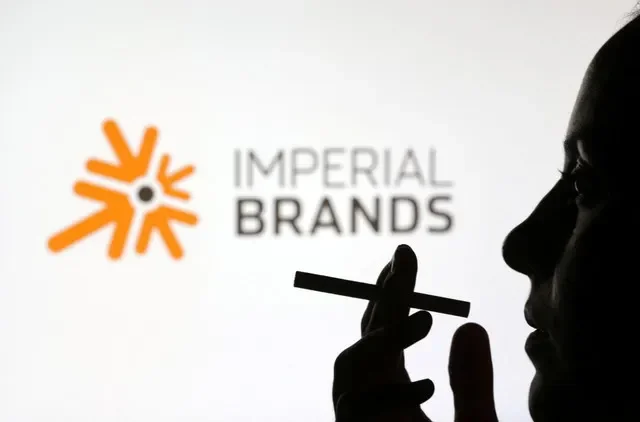 A woman poses with a cigarette in front of Imperial Brands logo in this illustration taken July 26, 2022. REUTERS/Dado Ruvic/Illustration