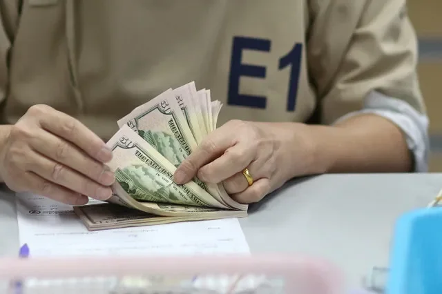 A bank employee counts U.S. dollar notes at a Kasikornbank in Bangkok, Thailand, January 26, 2023. REUTERS/Athit Perawongmetha