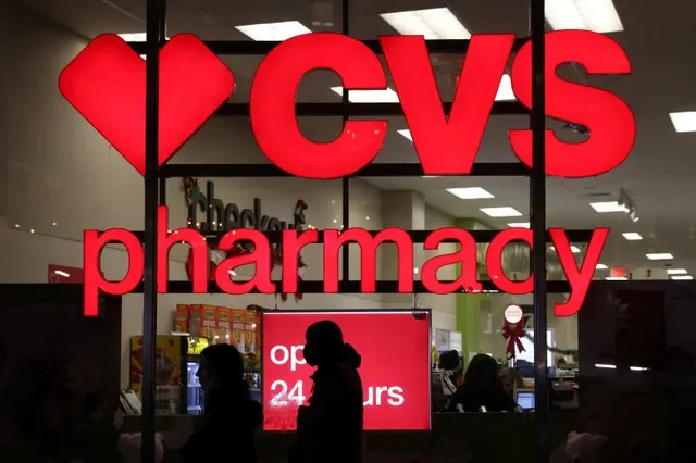 FILE PHOTO: People walk by a CVS pharmacy store in Manhattan, New York City, New York in this illustration, U.S., November 17, 2021. REUTERS/Andrew Kelly/File photo