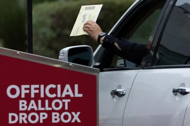 A voter drops off their election ballots at a drive-through ballot drop box outside the registrar of voters' office during the California primary election in San Diego, California, U.S., June 2, 2026. REUTERS/Mike Blake