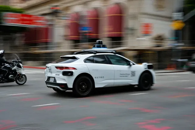 資料圖片:2026年5月1日,美國加州洛杉磯市中心,一名騎電單車的警員尾隨一輛行駛中的Waymo無人駕駛汽車。REUTERS/麥克·布萊克/資料圖片