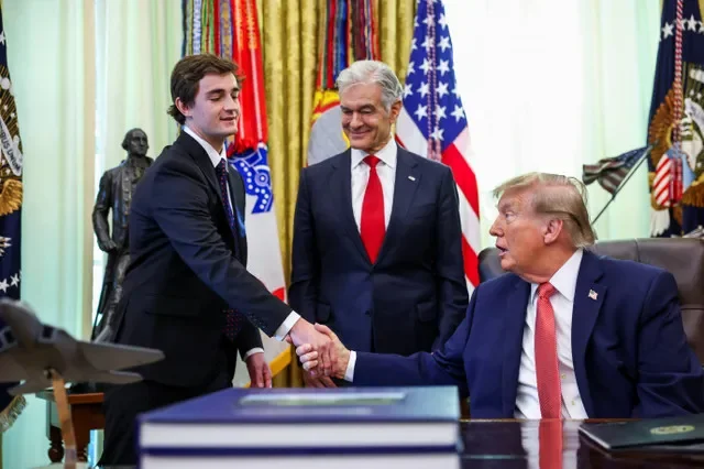 O influenciador digital conservador Nick Shirley aperta a mão do presidente dos EUA, Donald Trump, durante anúncio conjunto no Salão Oval sobre um programa de denunciantes que incentiva o público a relatar supostas fraudes, na Casa Branca em Washington, DC, EUA