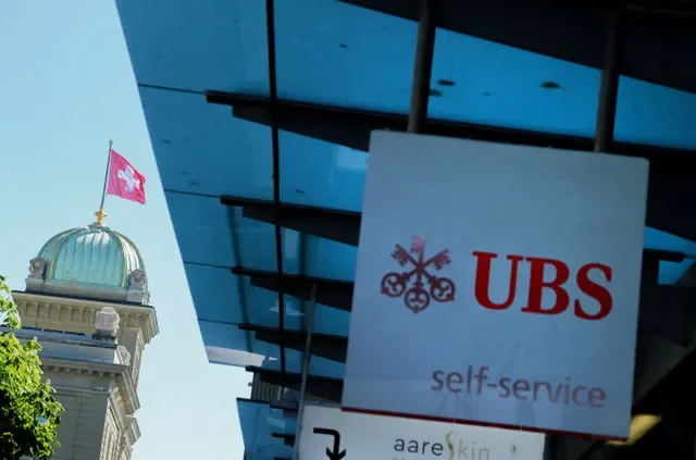 FOTO DE ARQUIVO: Logotipo do UBS em frente a uma bandeira suíça no edifício do Parlamento suíço antes de uma coletiva de imprensa sobre as exigências de capital dos bancos suíços em Berna, Suíça, 22 de abril de 2026. REUTERS/Denis Balibouse/Foto de arquivo