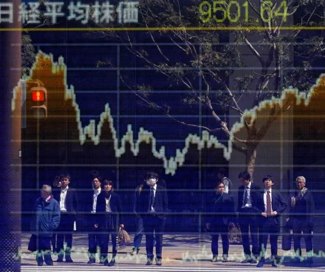 2011年3月28日,東京一家證券商外的股票行情看板上倒映出人影,看板顯示日經平均指數。路透社/花井亨