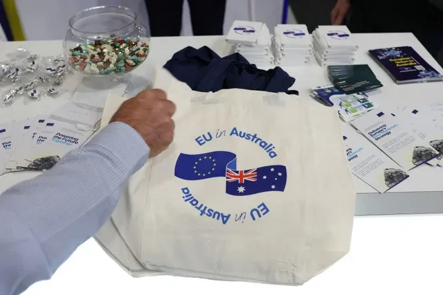 Um homem pega uma sacola onde se lê 'UE na Austrália' no pavilhão da União Europeia durante a Conferência Internacional de Mineração e Recursos (IMARC) em Sydney, Austrália, em 27 de outubro de 2026. REUTERS/Hollie Adams