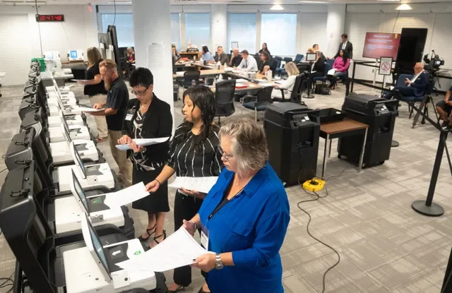 Miembros del personal de la oficina de la Supervisora de Elecciones del condado de Lee introducen boletas de prueba en las máquinas tabuladoras del día de la elección durante un proceso de prueba de lógica y precisión en la Oficina de la Supervisora de Elecciones del condado de Lee en Fort Myers, el miércoles 22 de julio de 2026.