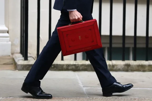 2026年10月28日，英國倫敦，英國財政大臣約翰·希利手提傳統紅色大臣公事包離開唐寧街11號，前往下議院發表首相安迪·伯納姆政府任內的首份預算案。REUTERS/Hannah McKay
