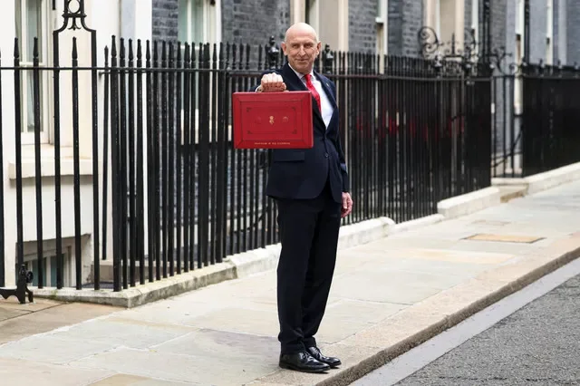 2026年10月28日,英國倫敦,英國財政大臣約翰·希利在唐寧街11號門外舉起傳統的紅色公事包,隨後前往下議院發表首相安迪·伯納姆政府的首份預算案。REUTERS/傑克·泰勒