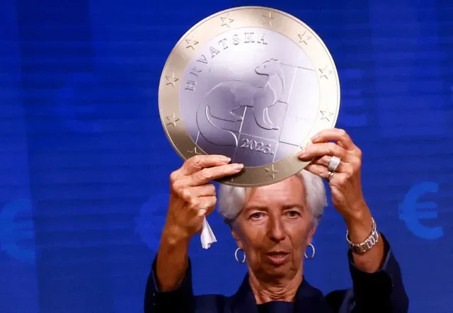 FILE PHOTO: President of European Central Bank Christine Lagarde poses with a model of a Euro coin after a signing ceremony on the adoption of the euro by Croatia in Brussels, Belgium July 12, 2022. REUTERS/Yves Herman/File Photo