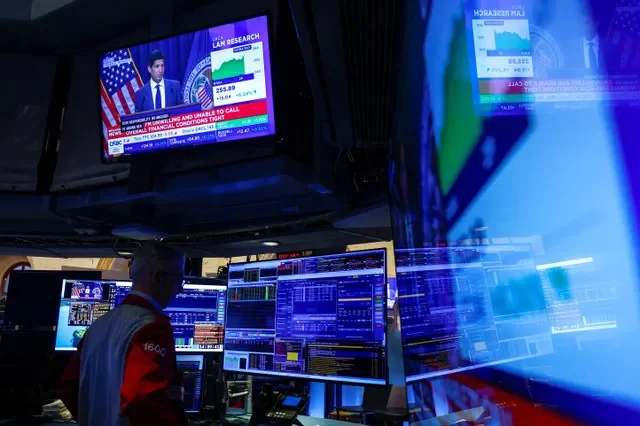Un operador trabaja mientras las pantallas retransmiten la rueda de prensa del presidente de la Reserva Federal de Estados Unidos, Kevin Warsh, tras el anuncio de los tipos de interés de la Fed, en el parqué de la Bolsa de Nueva York en la ciudad de Nueva York, Estados Unidos, el 28 de octubre de 2026. REUTERS/Jeenah Moon